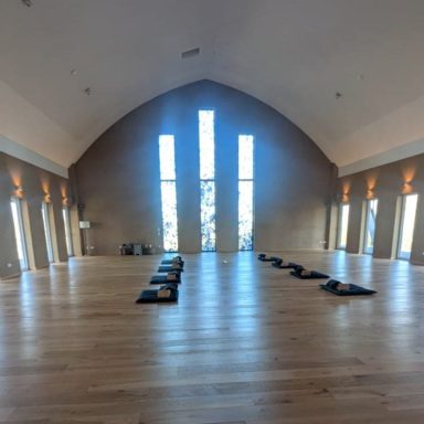 Heller Yogaraum mit großen Fenstern und Bodenmatten im Kloster zum Abschalten.